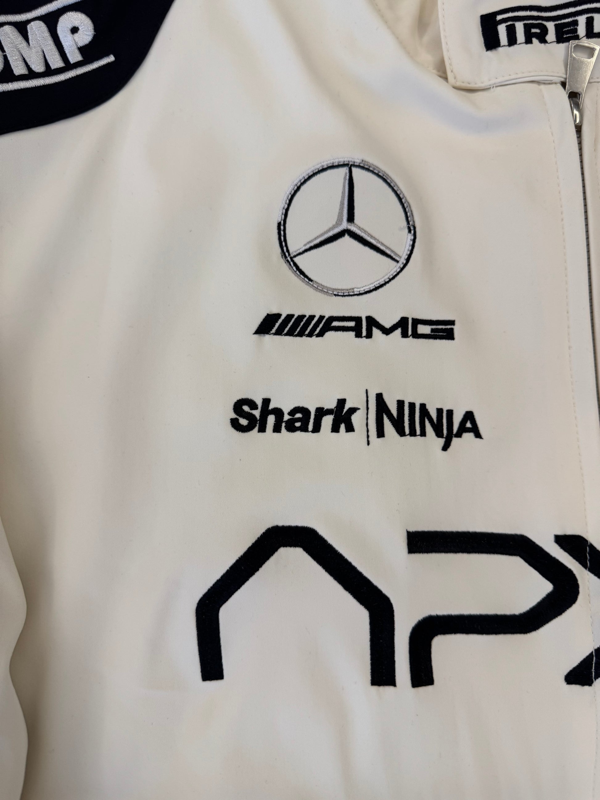 APX GP racing jacket front zip detail with embroidered APX logo and metallic hardware